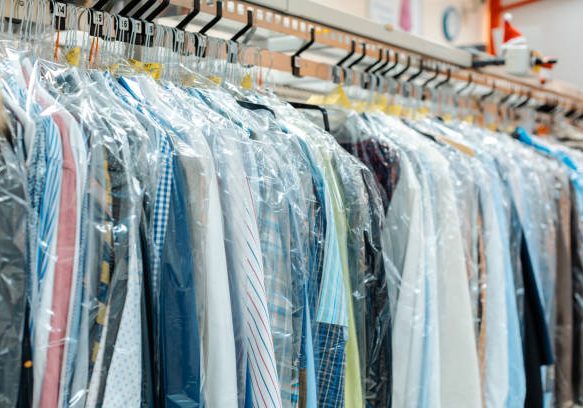 Carousel of clothing waiting for pick-up by their owners in dry cleaning shop Carousel of clothing waiting for pick-up by their owners in dry cleaning shop
